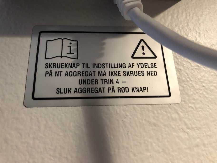 Advarselsskilt under ventilationsanlæggets betjeningspanel